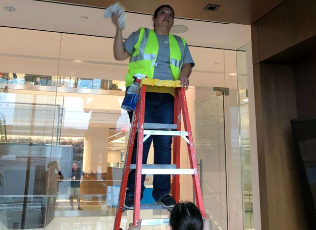 Crew member detailing overhead surfaces on a construction project